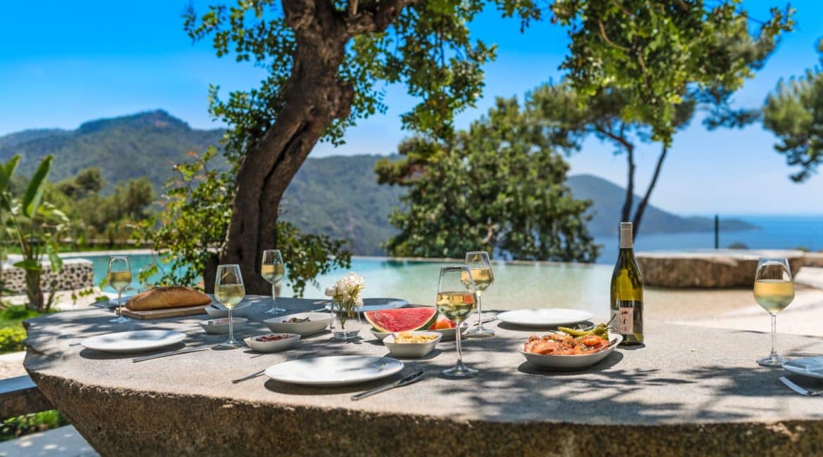 Gokce en plein air dining arrangements adjacent to the pool terrace