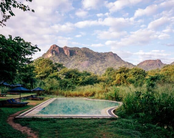 Gal Oya Lodge main swimming pool with panoramic views towards Monkey Mountain, set within lush wilderness of Gal Oya National Park, Sri Lanka.