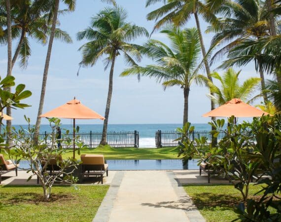 KK Beach Sri Lanka – tranquil setting with a beachfront swimming pool framed by palm trees and golden sand