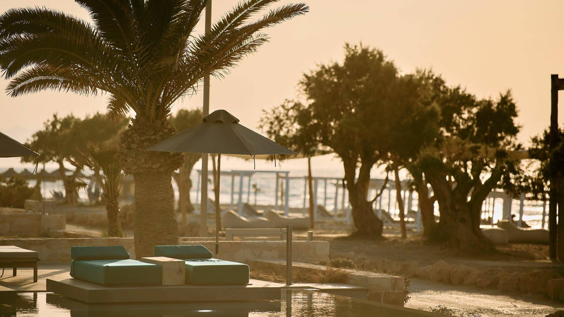 Paralos Kosta Alimia Beach Crete and swimming pool lit with golden rays