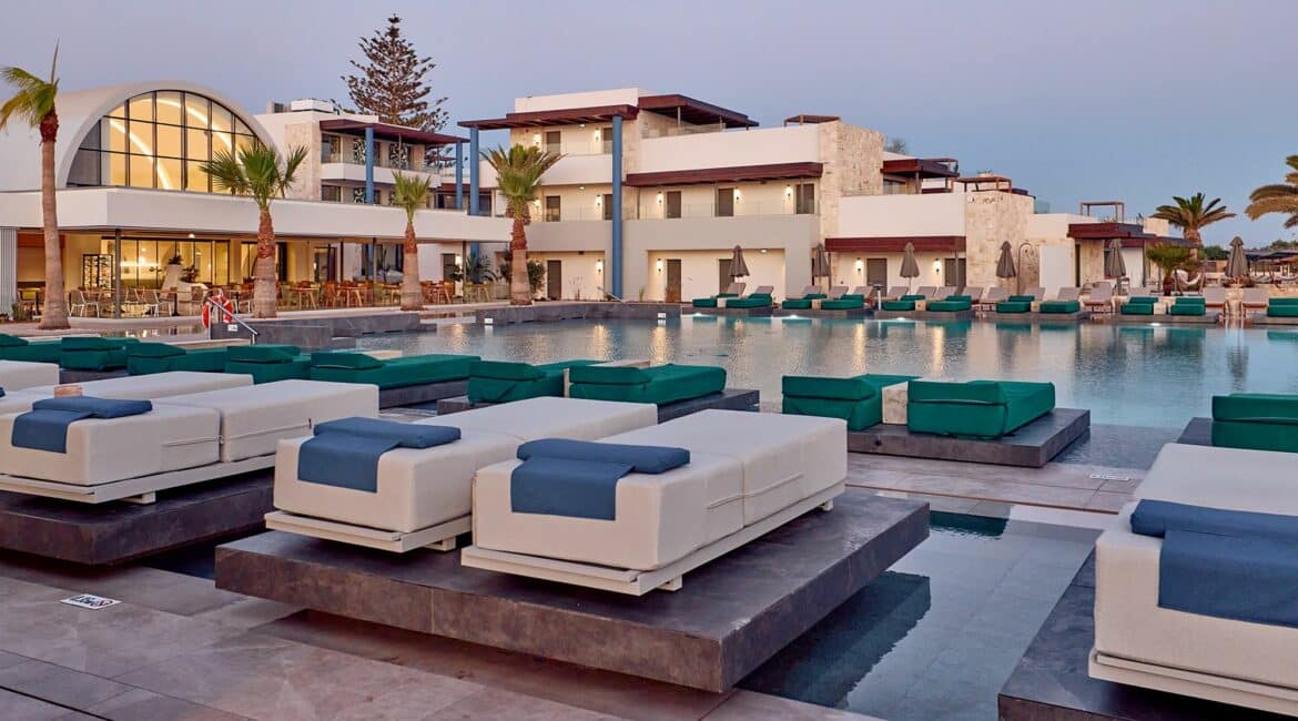 Paralos Kosta Alimia Beach Hotel and Pools replete day beds at dusk