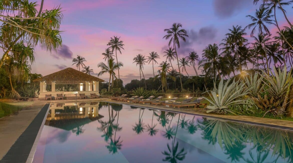 The Villa Bentota and swimming pool at sunset under a rainbow of pink skies