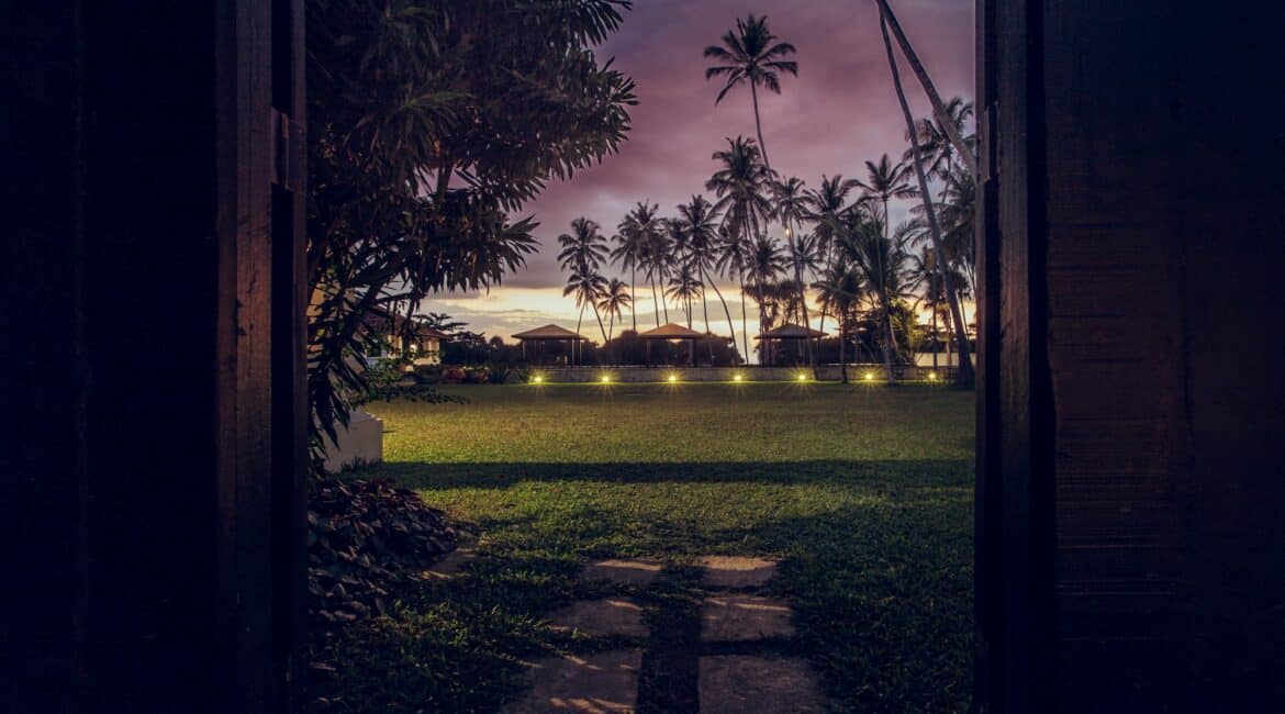 The Villa Bentota lawns under dusty pink skies