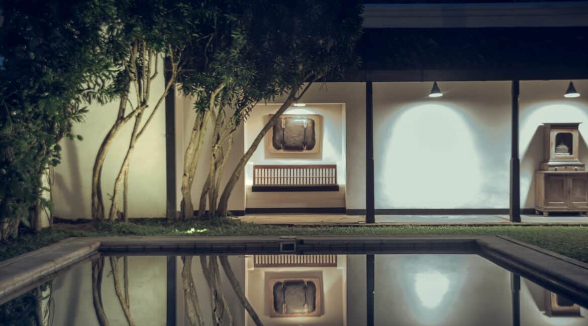 The Villa Bentota swimming pool by night in a courtyard setting
