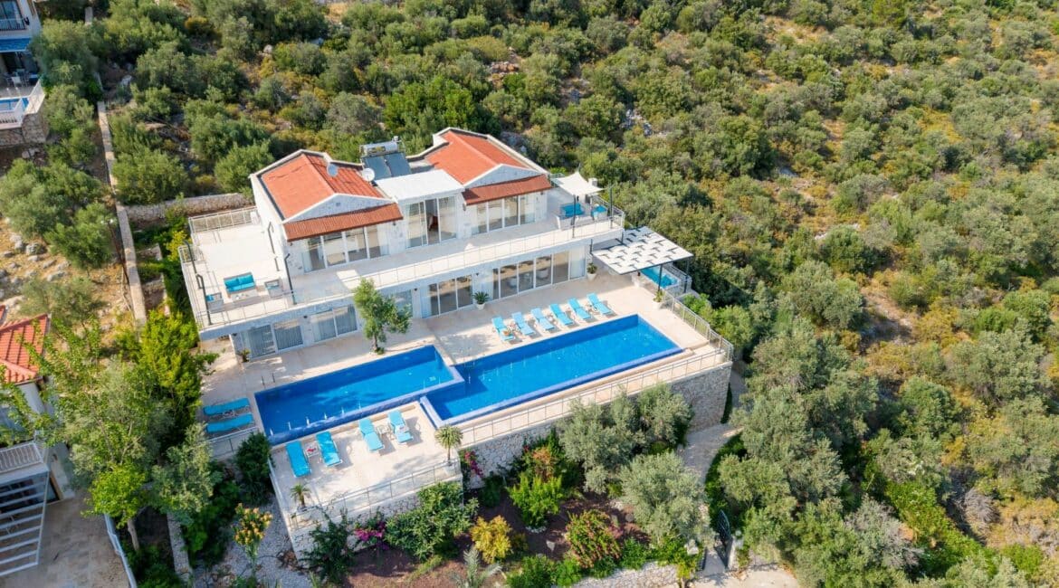 Villa Oasis Kalkan drone footage of its position with plenty of greenery as it sits at the end of a residential area