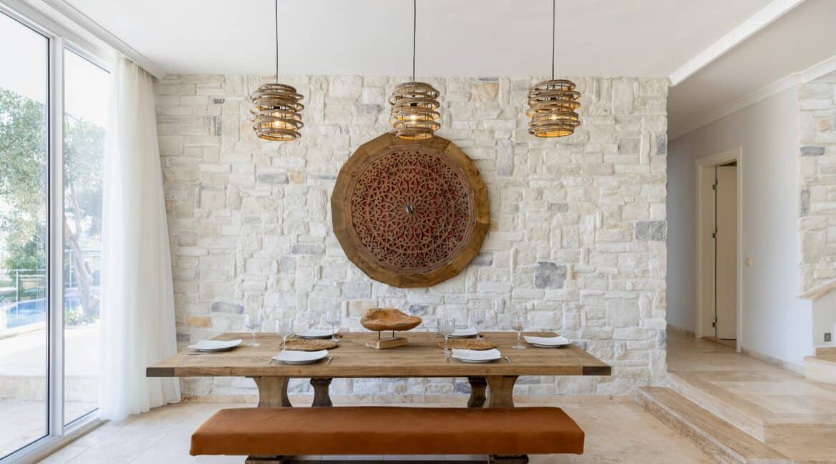 Villa Oasis Kalkan indoor dining area with floor to ceiling glass windows imbibing the surrounding terraces