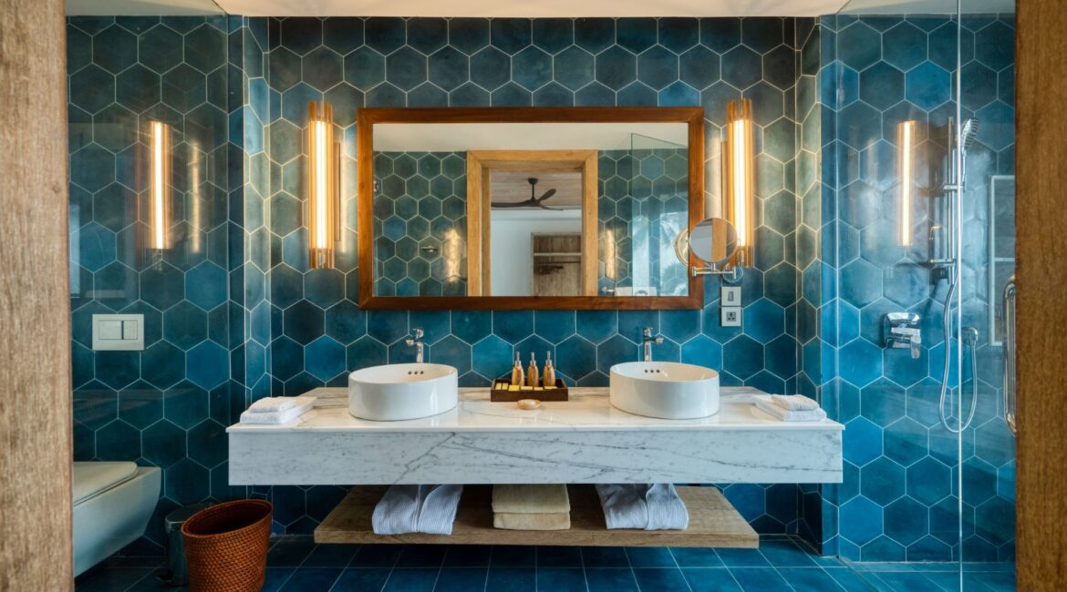 Bay View Room at Ahu Bay Sri Lanka with a spacious blue-tiled bathroom featuring a walk-in shower, twin vanities, and a WC.