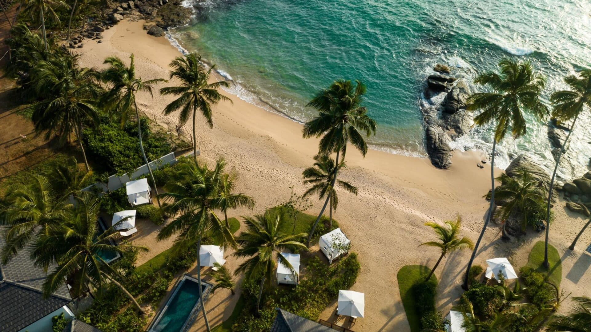 Aerial view of Ahu Bay Sri Lanka featuring the sandy beach, Indian Ocean, and pool rooms with private plunge pools overlooking the water.
