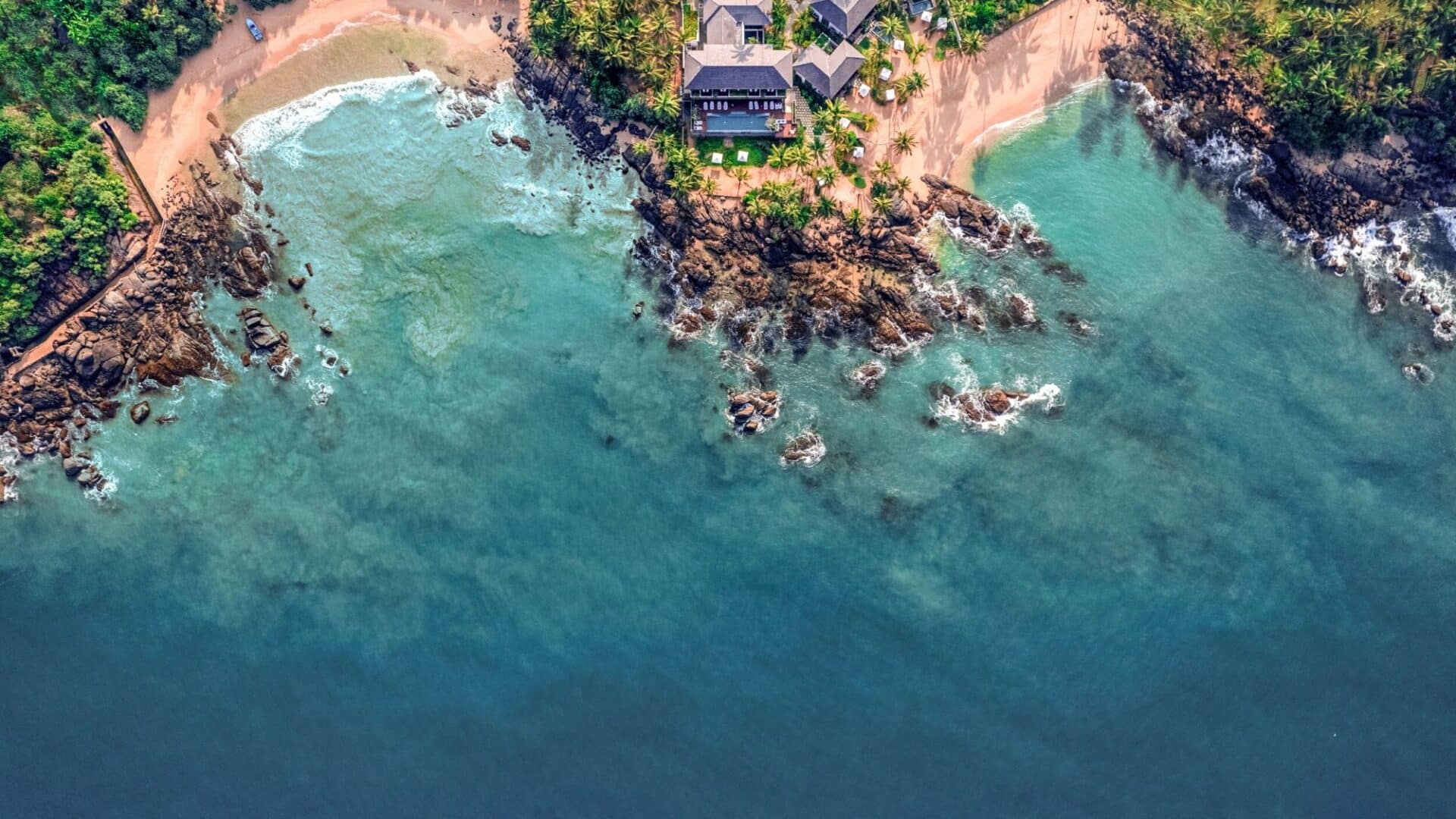 Aerial view of Ahu Bay Sri Lanka showing the hotel, sandy beach, and the vast Indian Ocean stretching to the horizon.