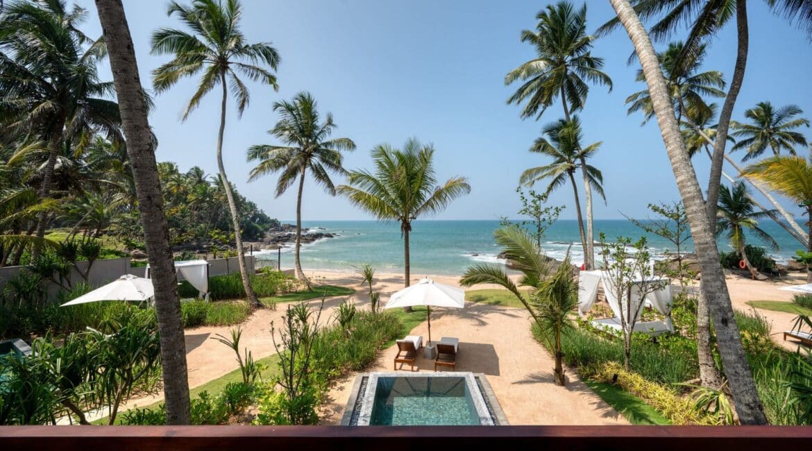 Gorgeous beach at Ahu Bay Sri Lanka with golden sand, palm trees, and gentle waves creating a tranquil coastal atmosphere.