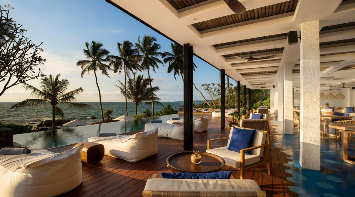 Relaxed poolside setting at Ahu Bay Sri Lanka with loungers overlooking the Indian Ocean.