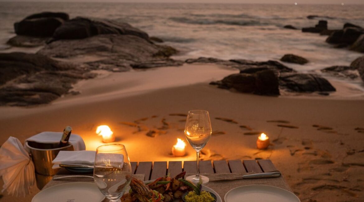 Romantic seaside supper setup at Ahu Bay Sri Lanka with candlelit tables overlooking the ocean.