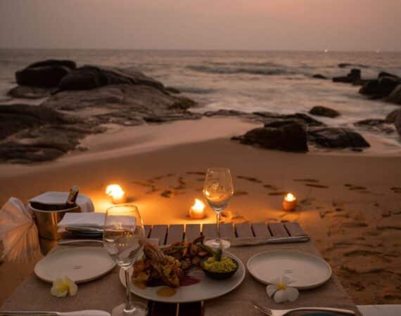 Romantic seaside supper setup at Ahu Bay Sri Lanka with candlelit tables overlooking the ocean.