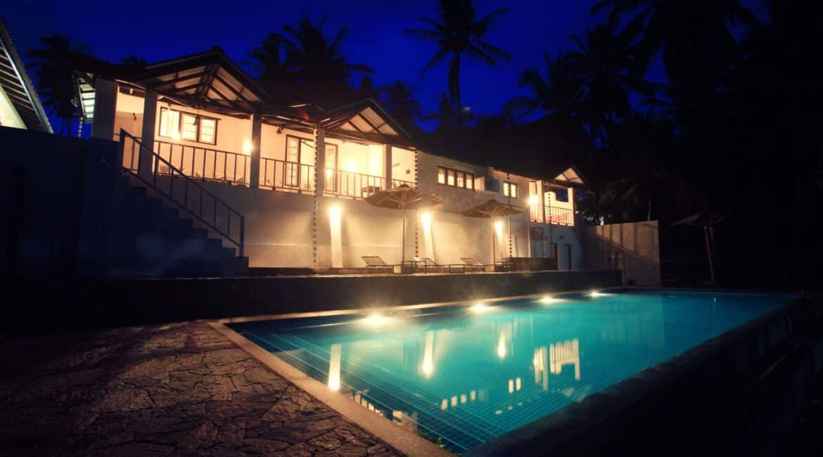 Coco Tangalla Hotel near Tangalle, Sri Lanka – serene dusk scene by the pool, with silhouetted palms and soft reflections in the water
