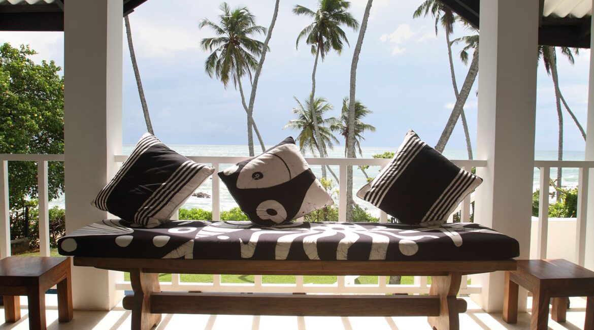 Shaded porch at Coco Tangalla near Tangalle, Sri Lanka, featuring a cushioned bench and uninterrupted views of the Indian Ocean.