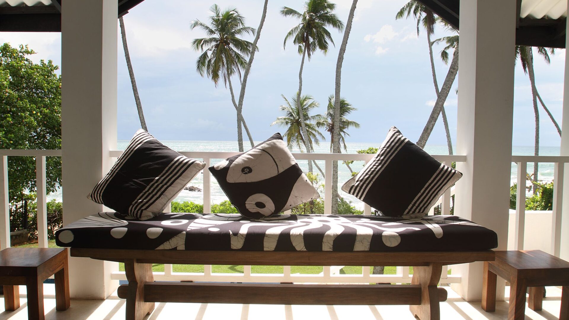 Shaded porch at Coco Tangalla near Tangalle, Sri Lanka, featuring a cushioned bench and uninterrupted views of the Indian Ocean.