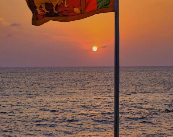 Sri Lankan national flag billowing at sunset in Colombo, Western Province – symbol of heritage and welcome at the gateway to Sri Lanka holidays.