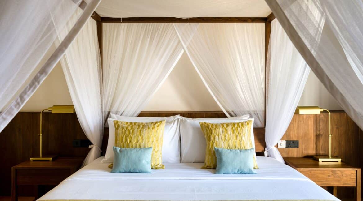Kayaam House Sri Lanka – Palm Residence featuring a stylish bedroom with a four-poster bed draped in chiffon nets and elegant, minimalist design.