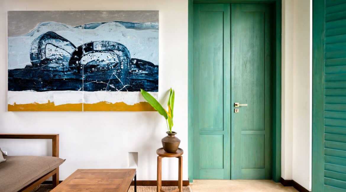 Kayaam House Sri Lanka – Palm Suite with stylish interiors, curated furnishings, and a distinctive green arched doorway leading to a private terrace.