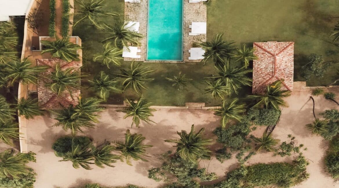 Kayaam House Sri Lanka – aerial footage capturing the hotel and swimming pool seamlessly leading onto a pristine, golden-sand beach.
