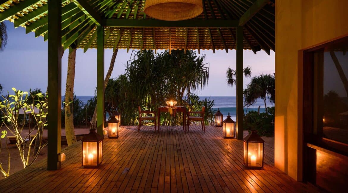 Kayaam House Sri Lanka – atmospheric evening dining experience beside the sea, with lanterns glowing and the sound of waves in the background.