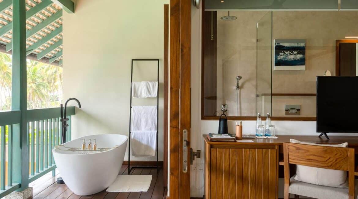 Kayaam House Sri Lanka – serene bedroom opening onto a private veranda with a freestanding outdoor bath.