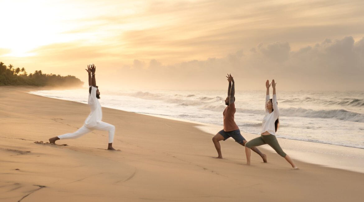 Kayaam House Sri Lanka – sunrise yoga on golden sands with waves crashing in the background and the horizon glowing with morning light.