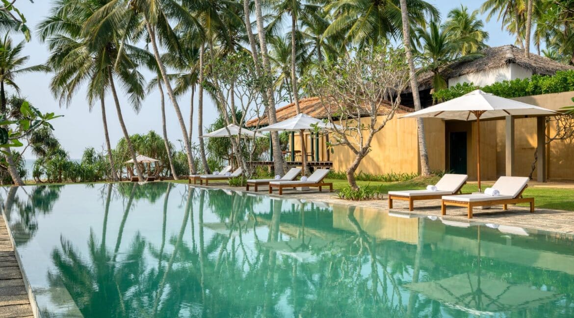 Kayaam House Sri Lanka – elegant swimming pool framed by shaded day beds and lush greenery.