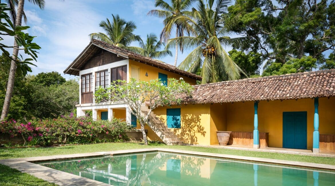 The Last House Tangalle Sri Lanka beautiful swimming pool and lawned grounds and the brightly coloured exterior of the building