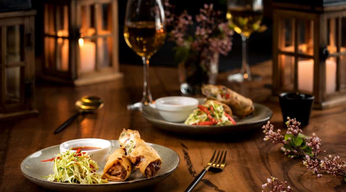 Crispy Asian-style spring rolls with salad garnish and a chilled glass of wine at Lantern Boutique Hotel, South Coast Sri Lanka – a light and elegant beachfront bite