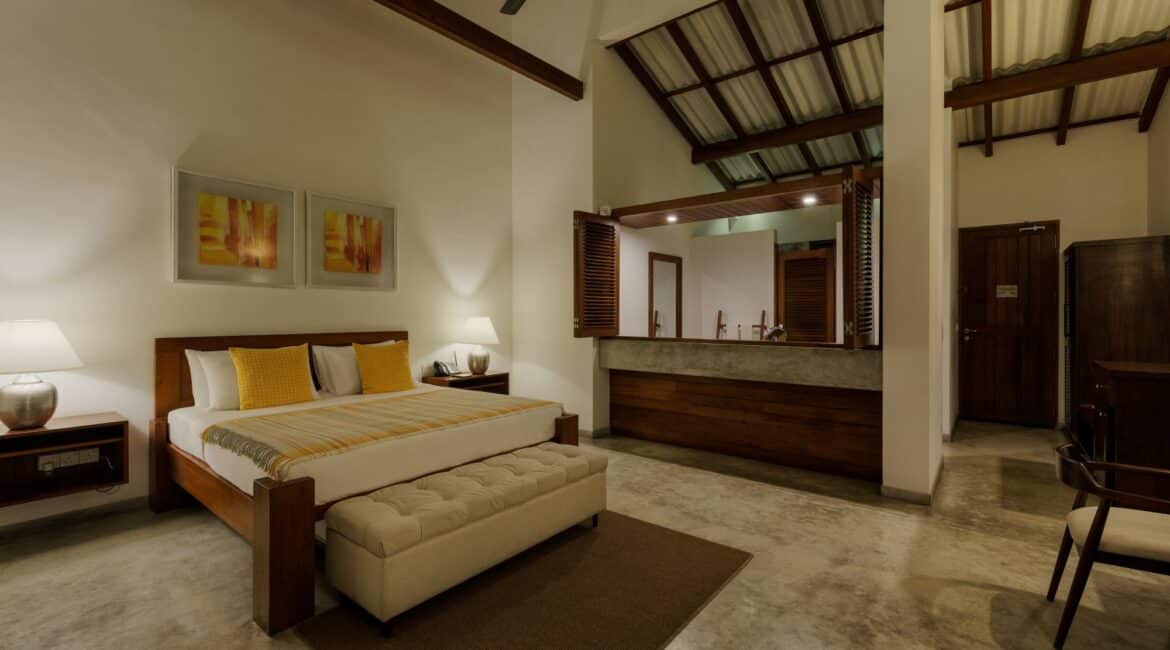 Deluxe Ocean Room at Lantern Boutique Hotel Sri Lanka – elegant bedroom with high ceilings, a neutral décor palette, and soft evening lighting creating a tranquil atmosphere
