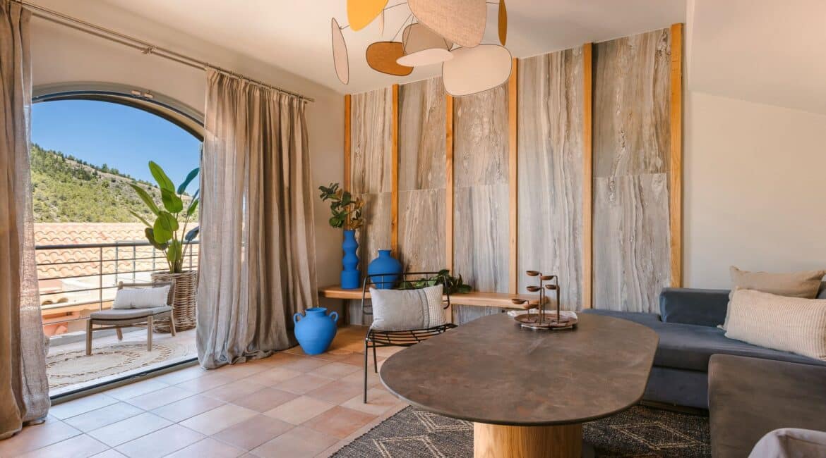 Open-plan lounge with comfortable seating and double doors to terrace at Villa Nikolis, Braunis Horio, Assos, Kefalonia.