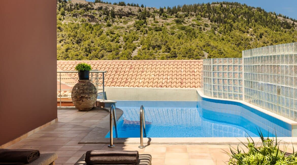 Unusual shaped pool framed by sunloungers at Villa Nikolis, Braunis Horio, Assos, Kefalonia.