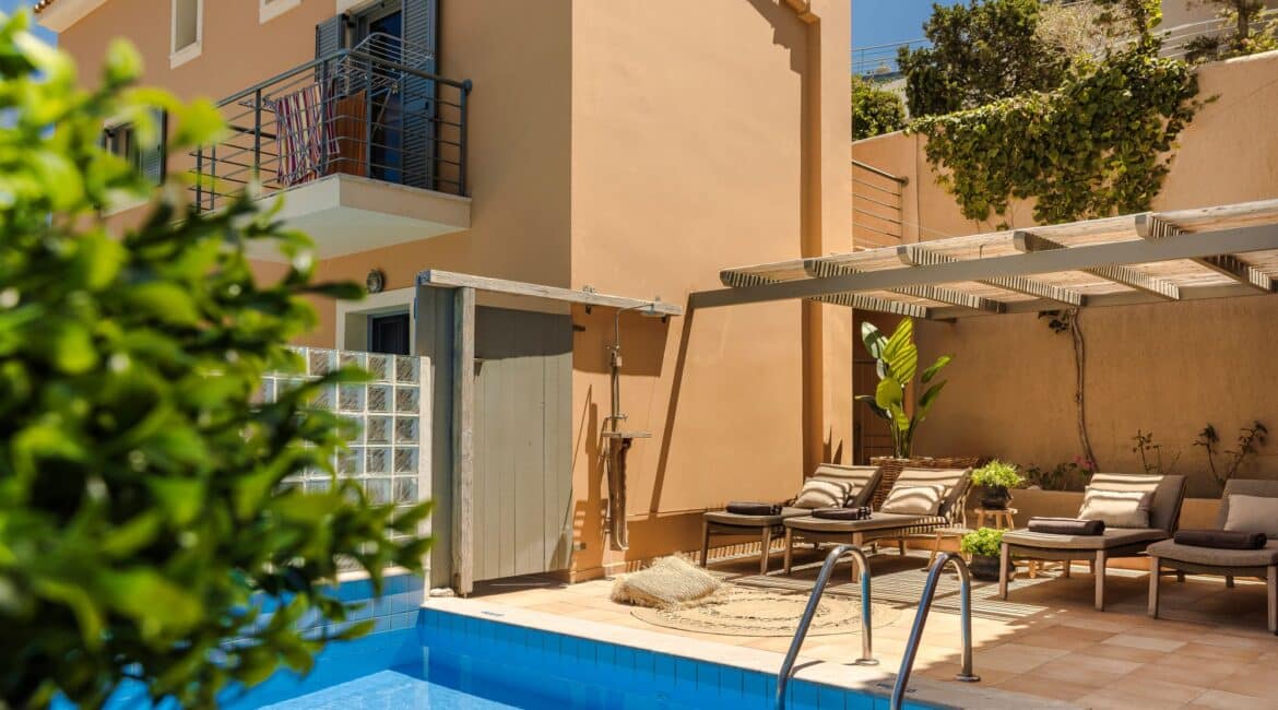 Uniquely shaped pool framed by sunloungers against the Villa Nikolis back drop, Braunis Horio, Assos, Kefalonia.