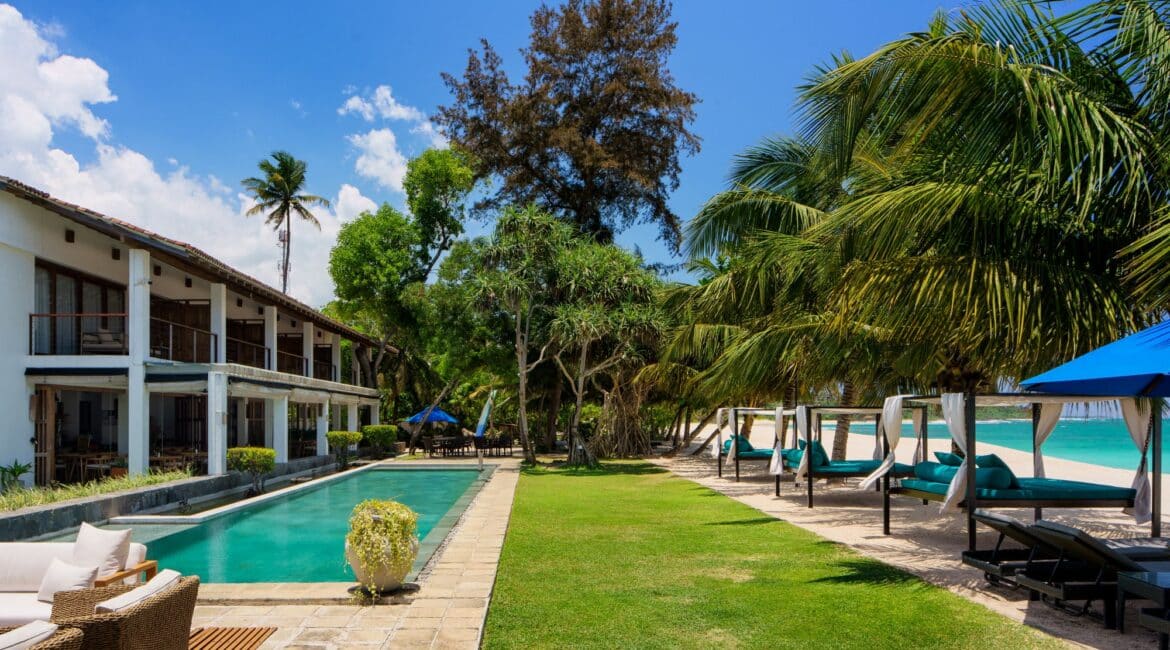 Lantern Boutique Hotel Sri Lanka – serene beachfront pool framed by immaculate green lawns, sea views, and the hotel’s elegant exterior, offering the perfect coastal retreat