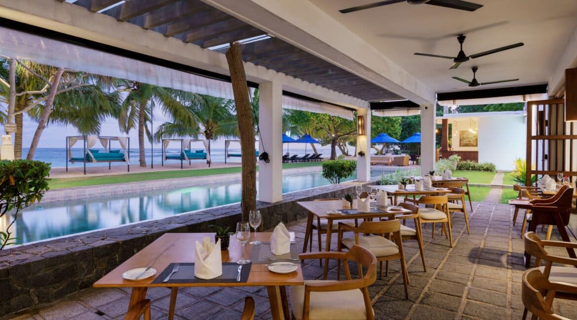 Lantern Boutique Hotel Sri Lanka – alfresco dining tables set for dinner beside the swimming pool with views of the beach and Indian Ocean