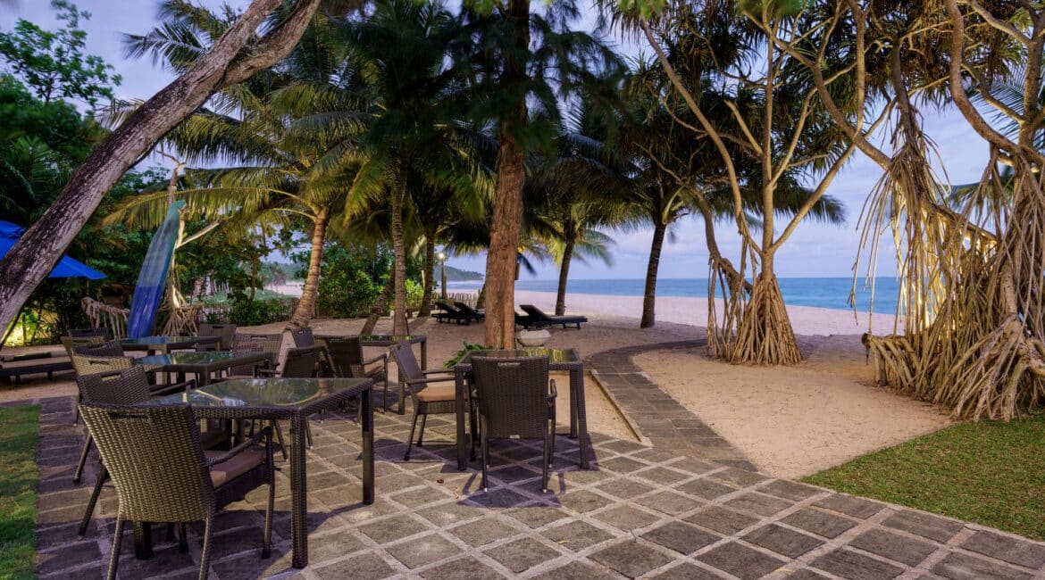 Lantern Boutique Hotel Sri Lanka – Alfresco dining terrace with panoramic views of the beach at dusk, where waves lap the shore just beyond