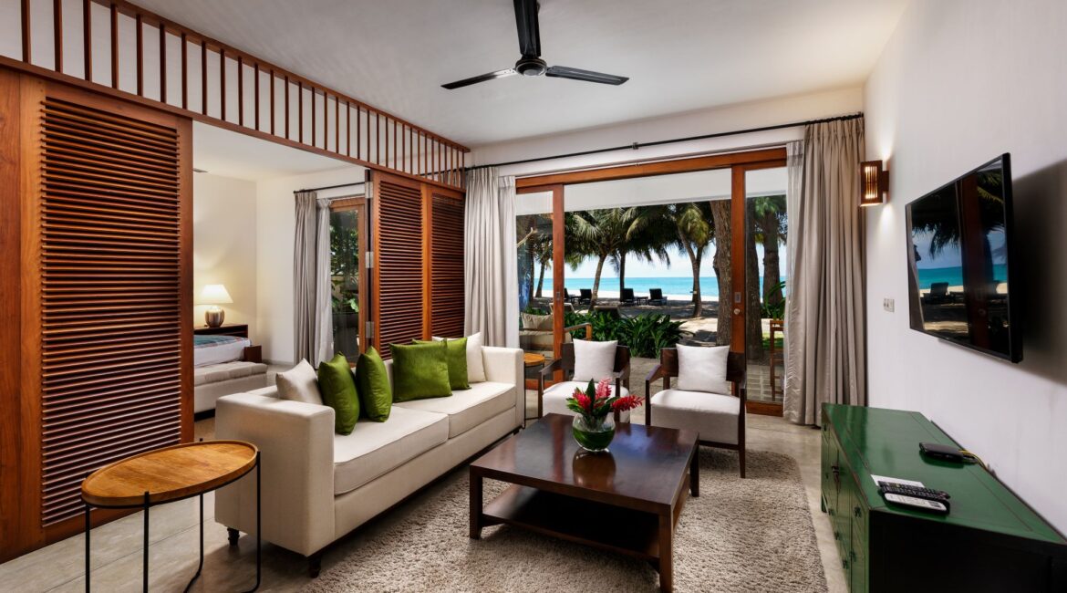 Ocean Suite at Lantern Boutique Hotel Sri Lanka spacious sitting area with a large sofa and glass doors opening directly onto the beach