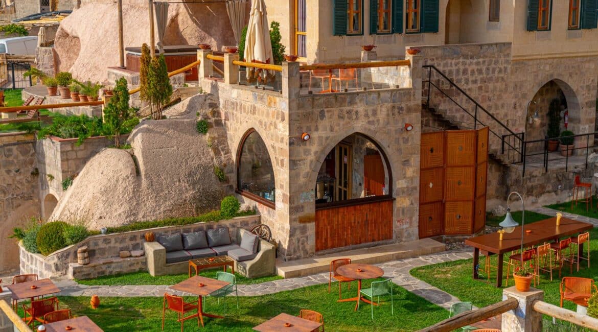 Taskonaklar Hotel with manicured gardens tables and hotel backdrop in Cappadocia