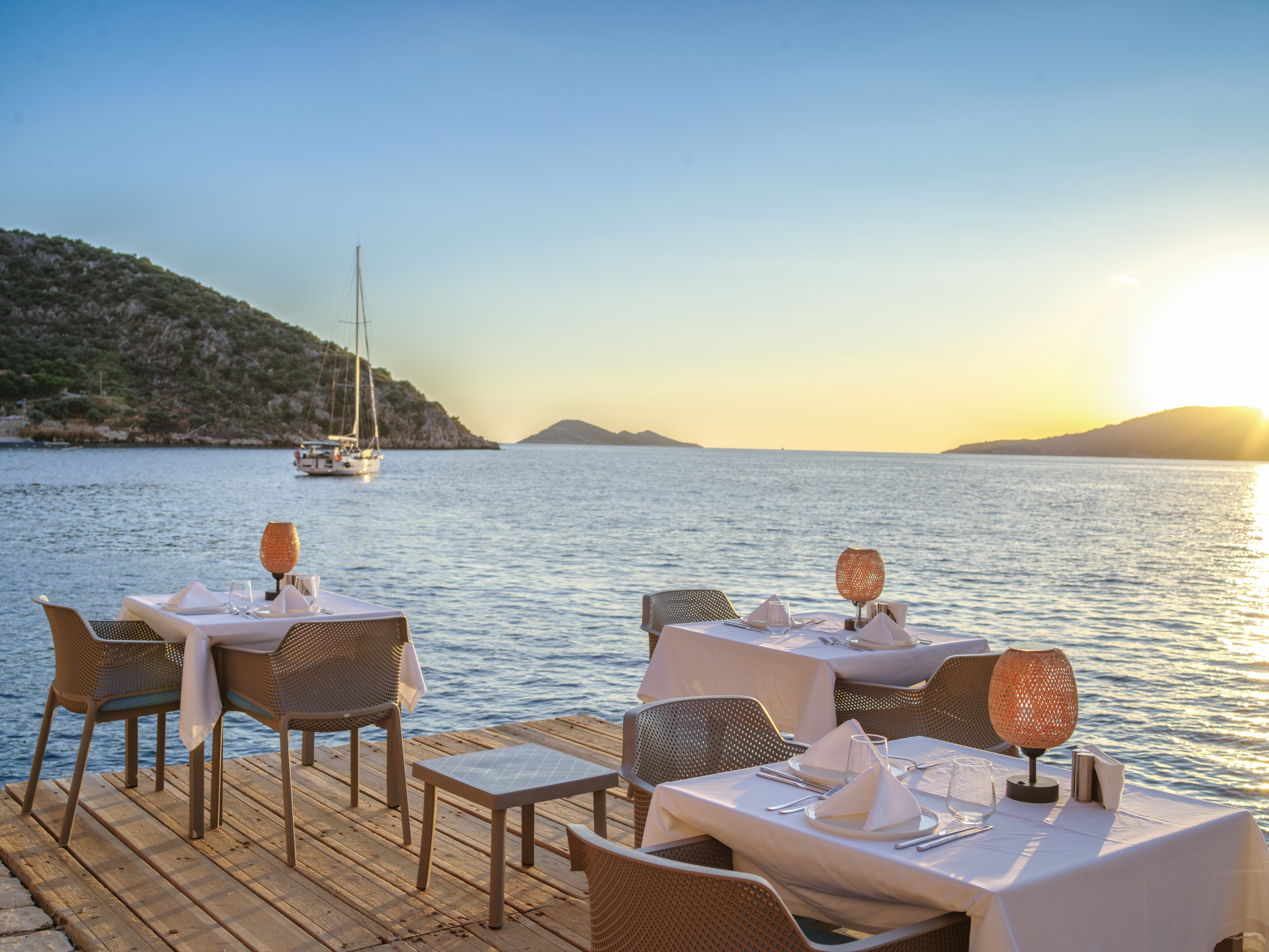 Waterside dining at Mahal Beach Club in Kalkan at dusk, overlooking luxury yachts and the Mediterranean on Turkey's beautiful Lycian Coast.
