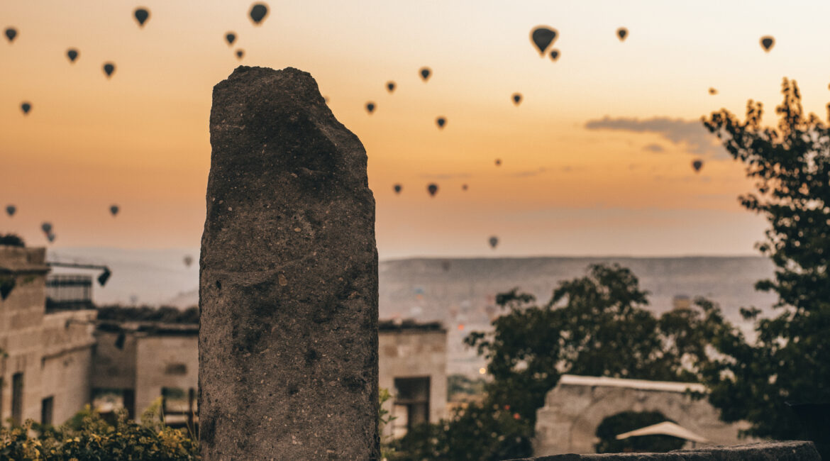 Museum Hotel Cappadocia sign with hot-air balloons rising at sunrise