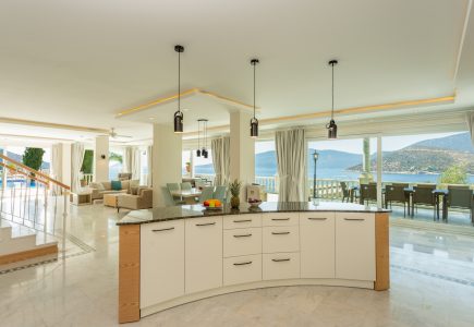 Open plan kitchen, dining and living area of Mavi Koy and views out across the bay